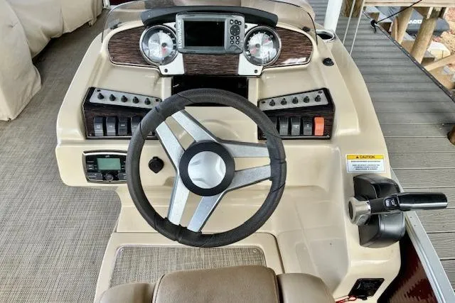 Slide: The Image of 2019 Godfrey Sweetwater boat dashboard with steering wheel and control panel. - 2