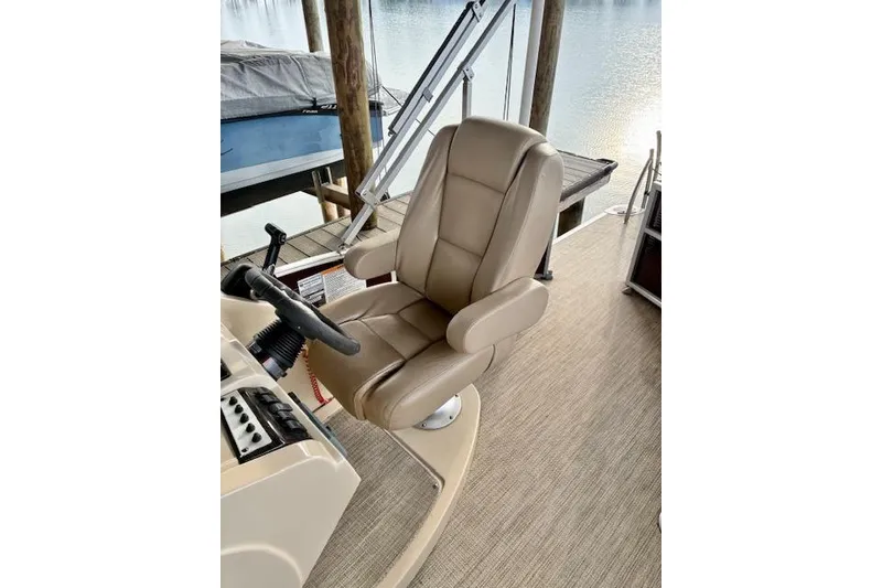 Slide: The Image of Captain's chair on 2019 Godfrey Sweetwater boat, docked by serene waters. - 6