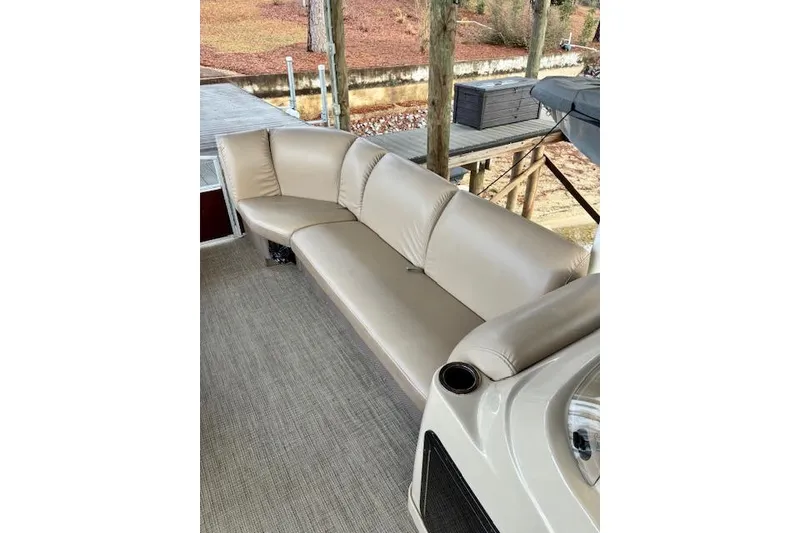 Slide: The Image of 2019 Godfrey Sweetwater boat with beige seating and cup holder on deck. - 7