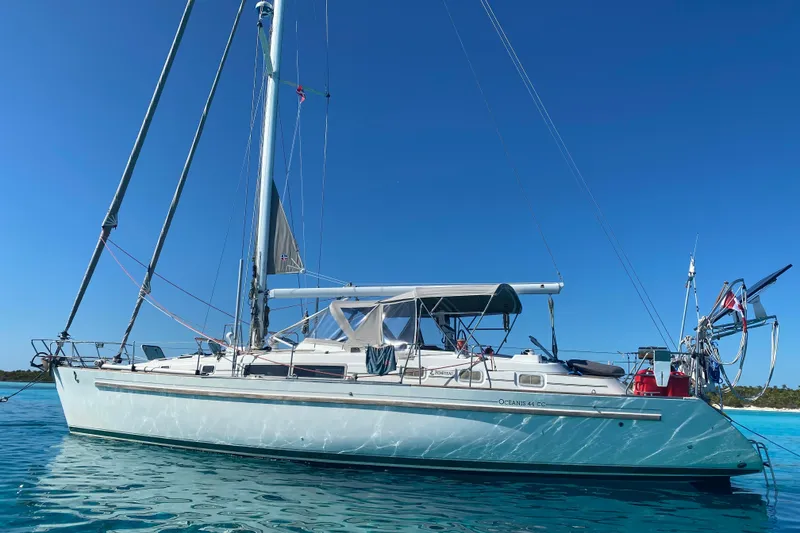 Slide: The Image of 1994 Beneteau Oceanis 44 CC sailboat anchored in clear blue water under a sunny sky. - 1