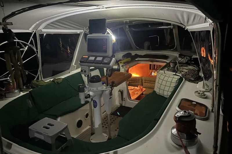 Slide: The Image of Cockpit view of 1994 Beneteau Oceanis 44 CC sailboat, featuring navigation equipment and cozy interior lighting. - 10