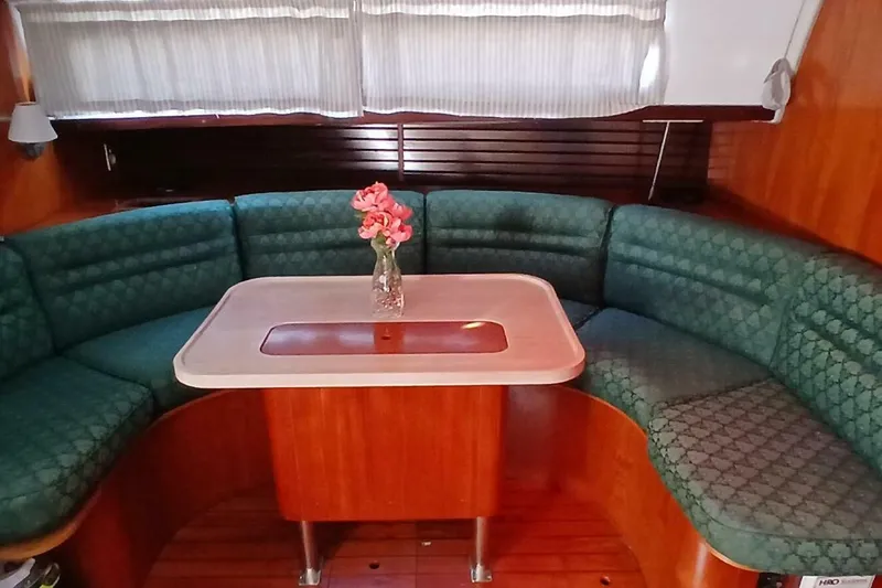 Slide: The Image of Interior of 1994 Beneteau Oceanis 44 CC with green seating and table. - 14