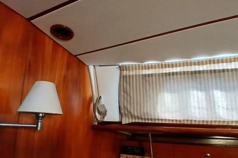 Slide: The Image of Interior of 1994 Beneteau Oceanis 44 CC yacht with wood paneling and striped curtains. - 18