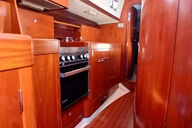 Slide: The Image of Interior of 1994 Beneteau Oceanis 44 CC yacht with wooden cabinetry and stove. - 24