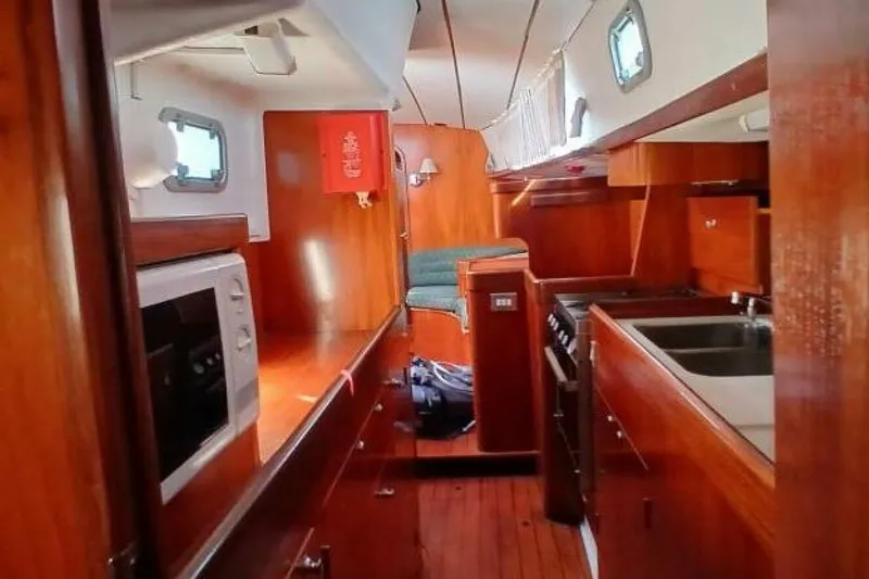 Slide: The Image of Interior of 1994 Beneteau Oceanis 44 CC sailboat with wood finish and kitchen amenities. - 26