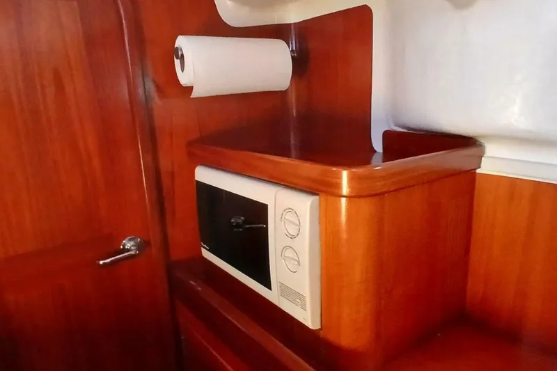 Slide: The Image of Wooden interior of 1994 Beneteau Oceanis 44 CC with microwave and paper towel holder. - 33