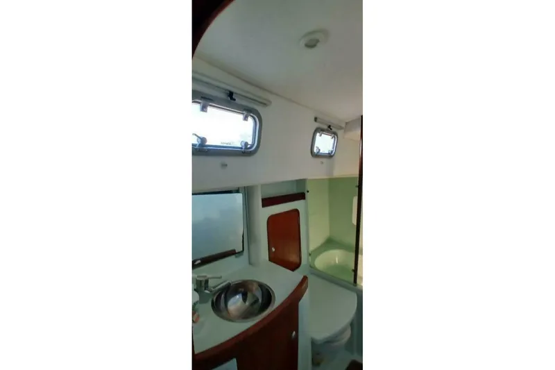 Slide: The Image of Interior of 1994 Beneteau Oceanis 44 CC yacht bathroom with sink and portholes. - 49