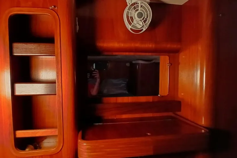 Slide: The Image of Interior of 1994 Beneteau Oceanis 44 CC yacht with wooden cabinetry and small fan. - 54