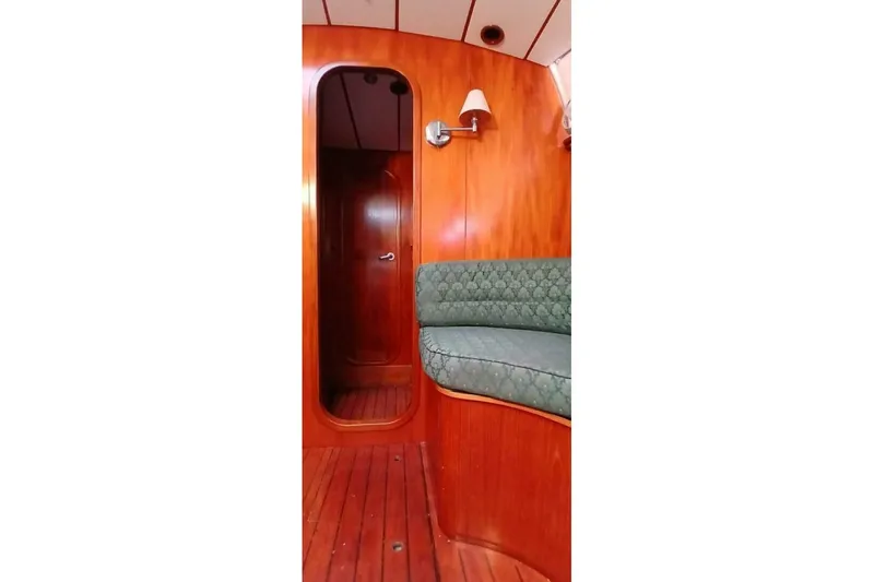 Slide: The Image of Interior of 1994 Beneteau Oceanis 44 CC yacht with wooden paneling and cushioned seating. - 55