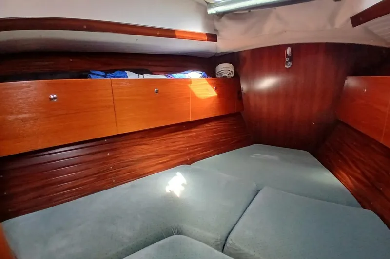 Slide: The Image of Cozy cabin interior of 1994 Beneteau Oceanis 44 CC with wooden storage and cushioned seating. - 62