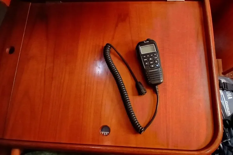 Slide: The Image of VHF radio handset on wooden surface of 1994 Beneteau Oceanis 44 CC yacht. - 72