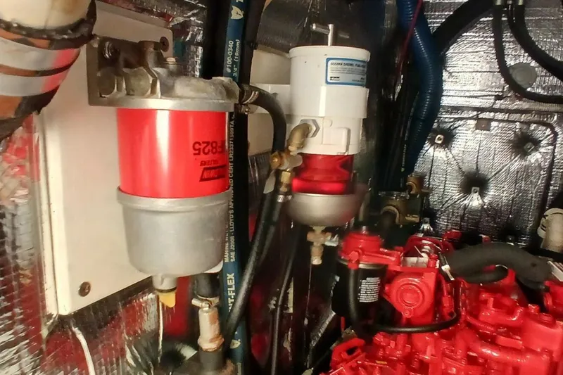 Slide: The Image of Engine room of 1994 Beneteau Oceanis 44 CC with fuel filters and red engine components. - 80