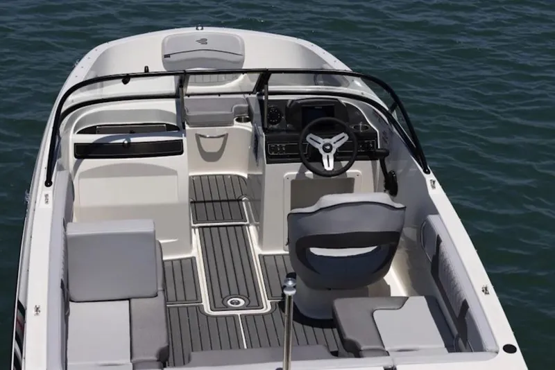 Slide: The Image of 2026 Bayliner VR4 Bowrider OB interior with steering wheel, seating, and open water view. - 2