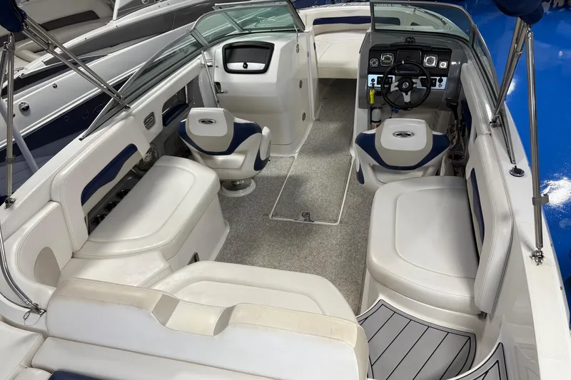 Slide: The Image of 2012 Chaparral 246 SSi boat interior with white seating and modern dashboard. - 4