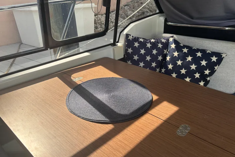 Slide: The Image of Interior of 2022 Jeanneau NC 795 Series 2 with star-patterned cushions and wooden table. - 3