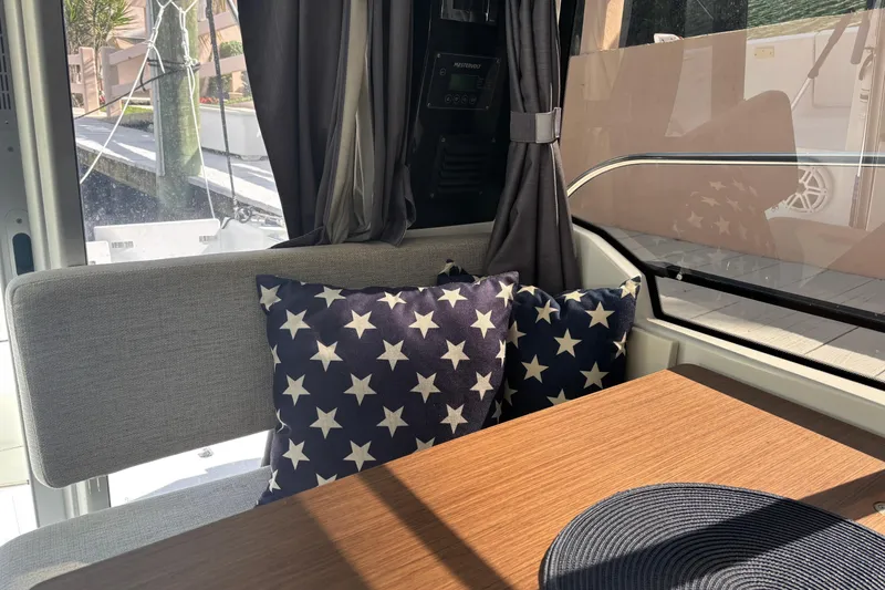 Slide: The Image of Interior of 2022 Jeanneau NC 795 Series 2 with star-patterned cushions and wooden table. - 4