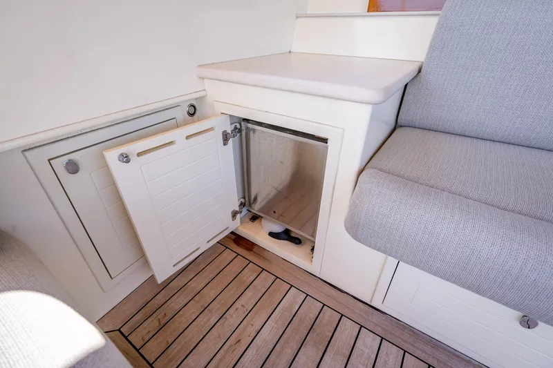 Slide: The Image of 2018 Palm Beach Motor Yachts PB50 interior with open storage compartment and cushioned seating. - 10