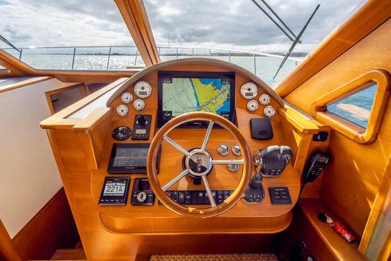Slide: The Image of 2018 Palm Beach Motor Yachts PB50 helm with navigation instruments and wooden steering wheel. - 17