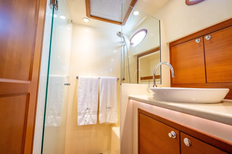 Slide: The Image of Luxurious bathroom in 2018 Palm Beach Motor Yachts PB50, featuring elegant wood cabinetry and modern fixtures. - 25
