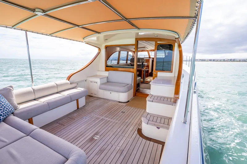 Slide: The Image of 2018 Palm Beach Motor Yachts PB50, luxurious deck with seating, cruising on open water. - 1