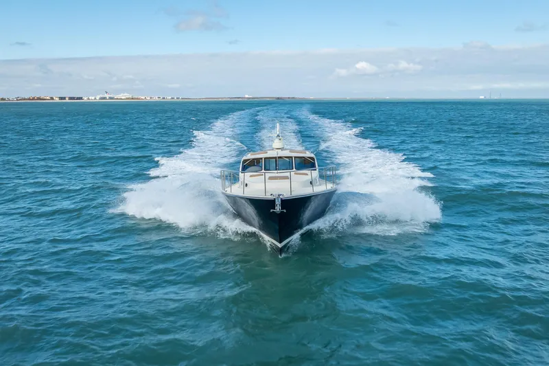 Slide: The Image of 2018 Palm Beach Motor Yachts PB50 cruising on open water, creating a dynamic wake. - 38