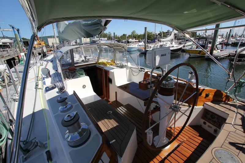 Slide: The Image of Cockpit of 1998 Able Apogee 50 sailboat docked at marina, featuring wooden deck and steering wheel. - 12