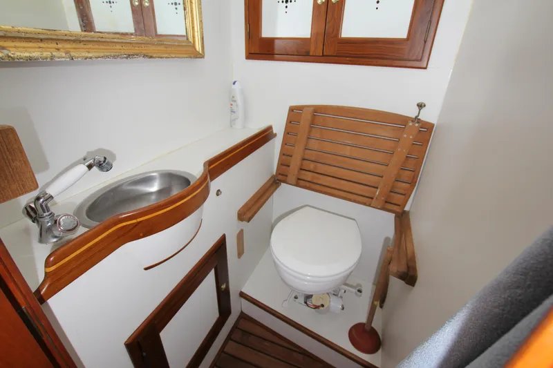Slide: The Image of Compact boat bathroom with wooden accents, featuring a sink and toilet. Able Apogee 50, 1998 model. - 19
