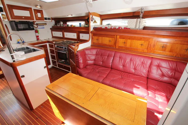 Slide: The Image of Luxurious 1998 Able Apogee 50 yacht interior with red leather seating and wooden cabinetry. - 21