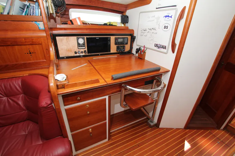 Slide: The Image of Navigation station in 1998 Able Apogee 50 sailboat with wooden desk and equipment. - 28