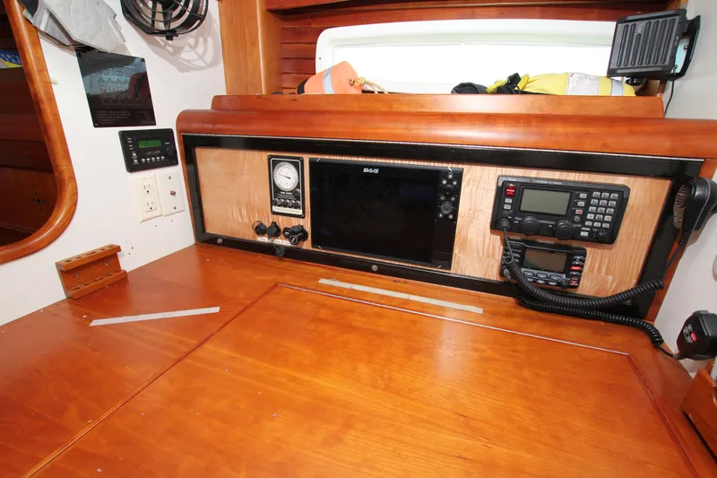 Slide: The Image of 1998 Able Apogee 50 yacht navigation station with control panels and communication devices. - 29