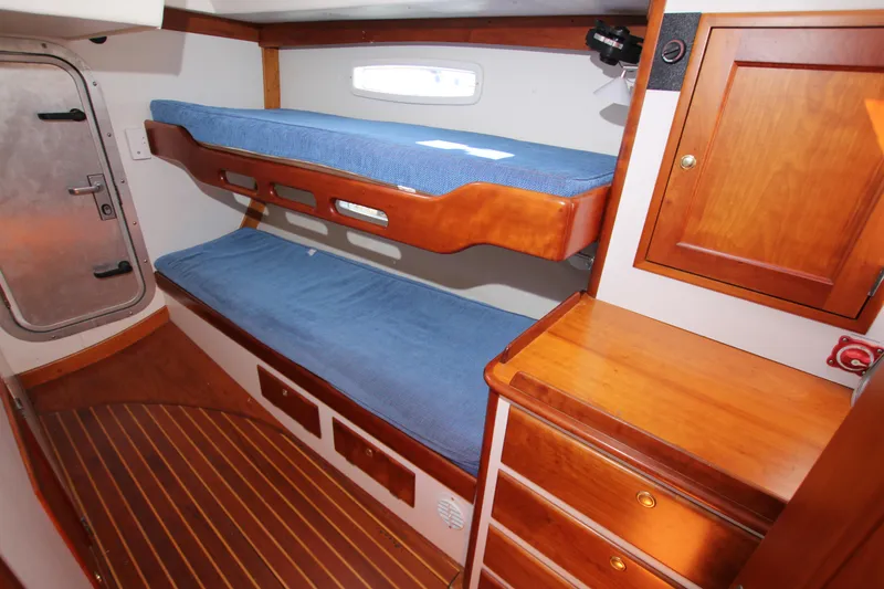 Slide: The Image of 1998 Able Apogee 50 yacht cabin with wooden interior and blue bunk beds. - 32