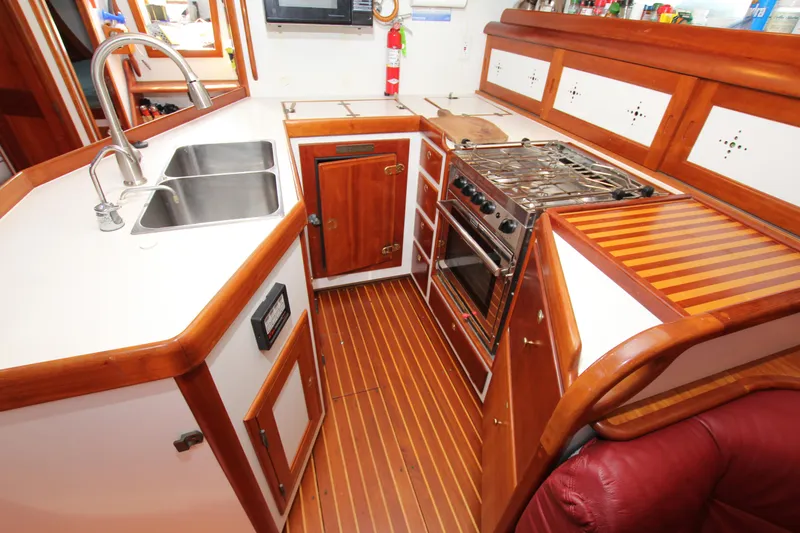Slide: The Image of 1998 Able Apogee 50 yacht kitchen with wooden cabinetry, dual sink, and stove. - 34