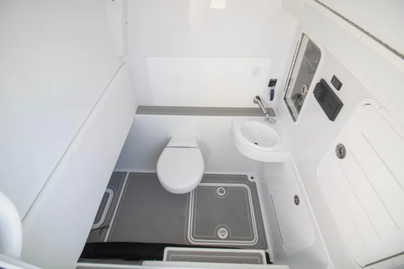 Slide: The Image of Interior of 2026 Invincible 39 Open Fisherman boat bathroom, featuring toilet and sink. - 21