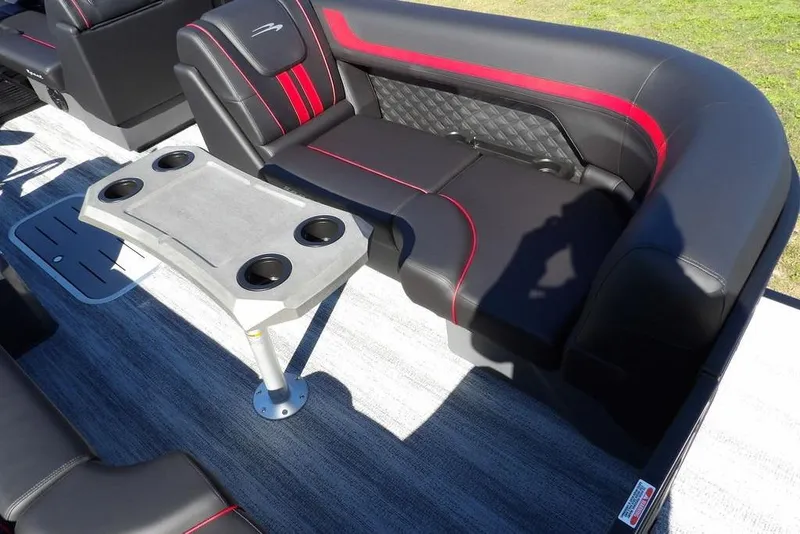 Slide: The Image of 2026 Bennington S Swingback 22 SSB interior with black and red seating, cupholder table. - 13
