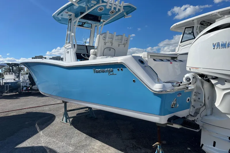 The Image of 2026 Tidewater 272 CC Adventure boat in vibrant blue, docked under a clear sky. - 0