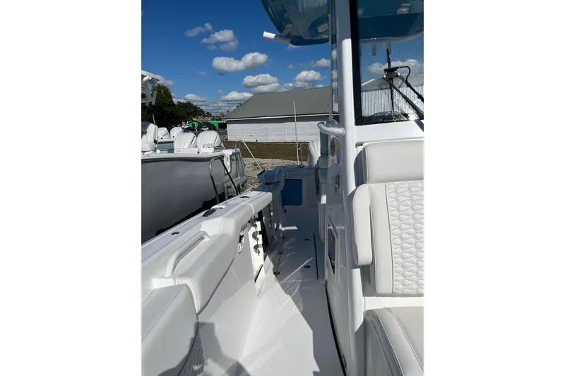 Slide: The Image of 2026 Tidewater 272 CC Adventure boat interior with white seating and clear skies. - 13