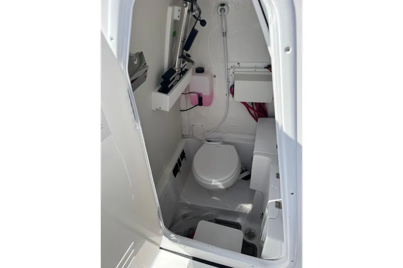 Slide: The Image of Interior of 2026 Tidewater 272 CC Adventure boat's compact bathroom with toilet and storage. - 14