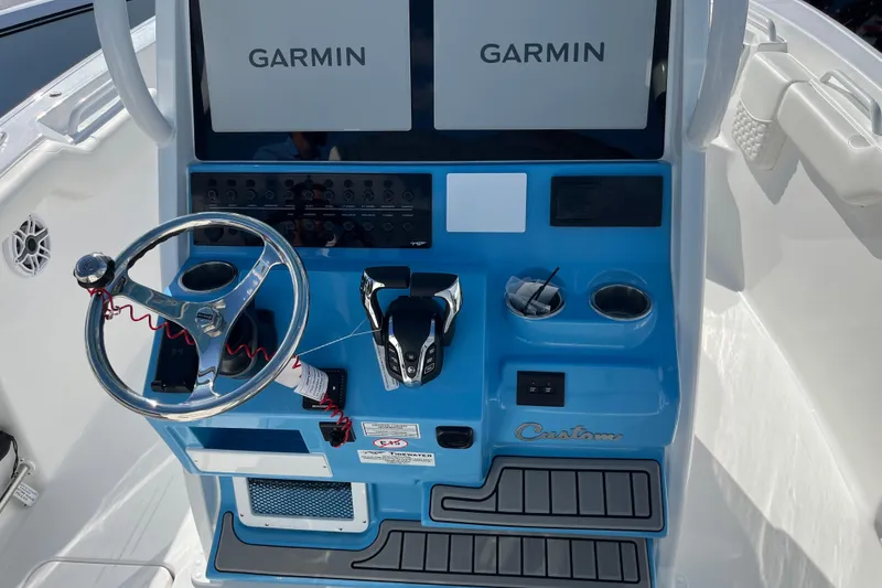 Slide: The Image of 2026 Tidewater 272 CC Adventure boat console with Garmin displays and steering wheel. - 16