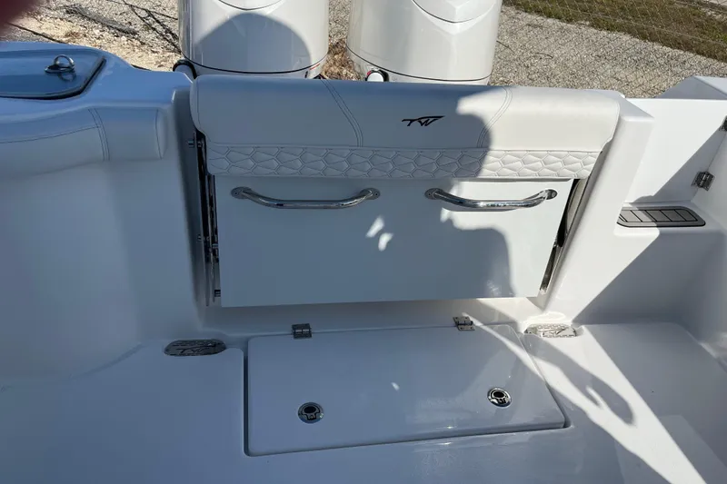 Slide: The Image of 2026 Tidewater 272 CC Adventure boat interior with white seating and storage area. - 21