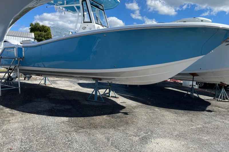 Slide: The Image of 2026 Tidewater 272 CC Adventure boat on stands, blue hull, outdoor setting. - 3