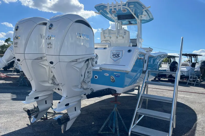 Slide: The Image of 2026 Tidewater 272 CC Adventure boat with dual Yamaha engines, docked under a clear sky. - 4