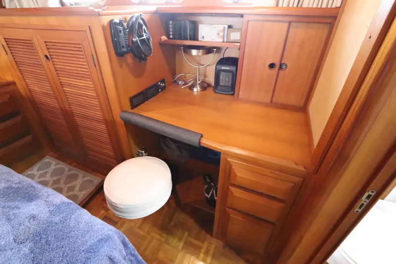 Slide: The Image of 2005 DeFever 49 Cockpit Motor Yacht interior with wooden desk and storage cabinets. - 101