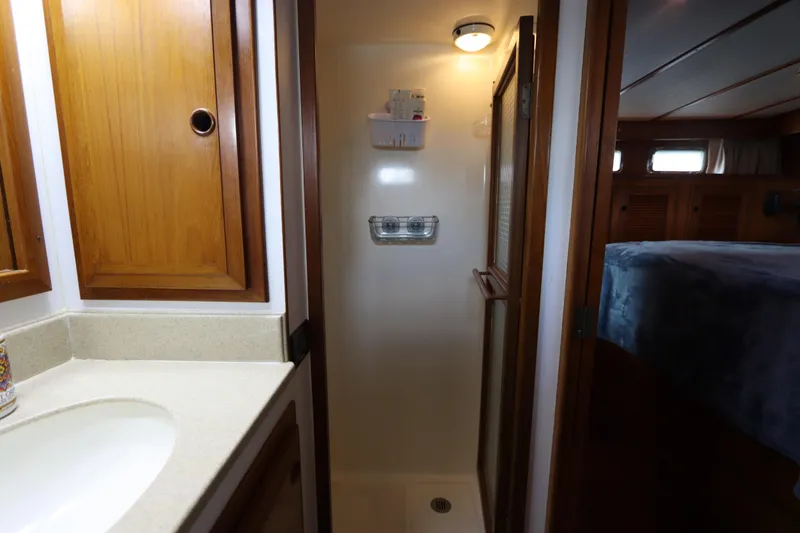 Slide: The Image of 2005 DeFever 49 Cockpit Motor Yacht bathroom with shower and wooden cabinetry. - 105