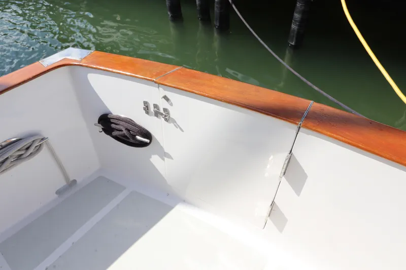 Slide: The Image of 2005 DeFever 49 Cockpit Motor Yacht deck with wood trim and mooring ropes. - 11