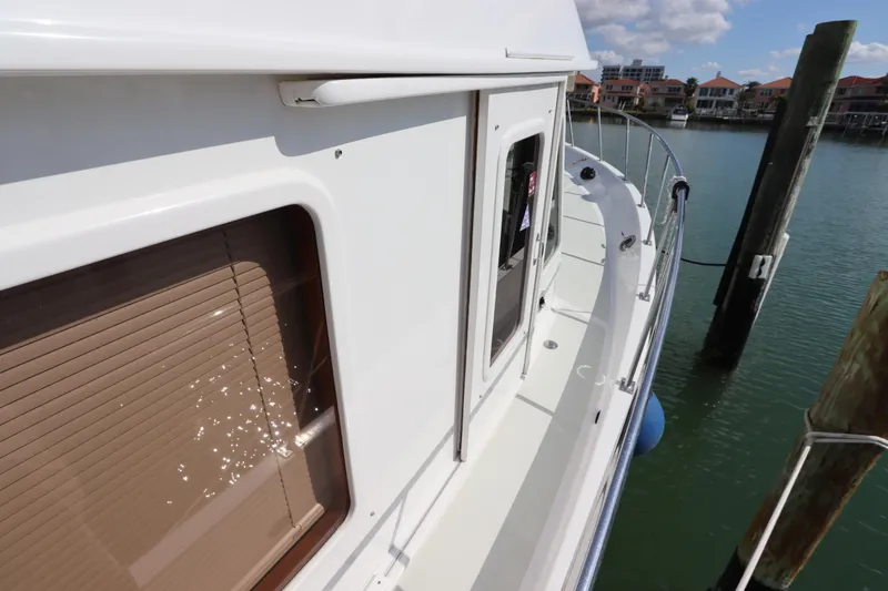 Slide: The Image of 2005 DeFever 49 Cockpit Motor Yacht docked, side view with water reflections. - 16