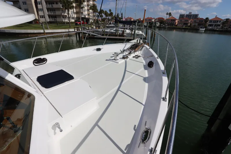 Slide: The Image of 2005 DeFever 49 Cockpit Motor Yacht docked at marina, showcasing spacious deck. - 17