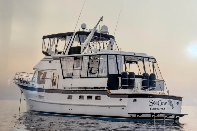 Slide: The Image of 2005 DeFever 49 Cockpit Motor Yacht on calm water at sunset. - 2