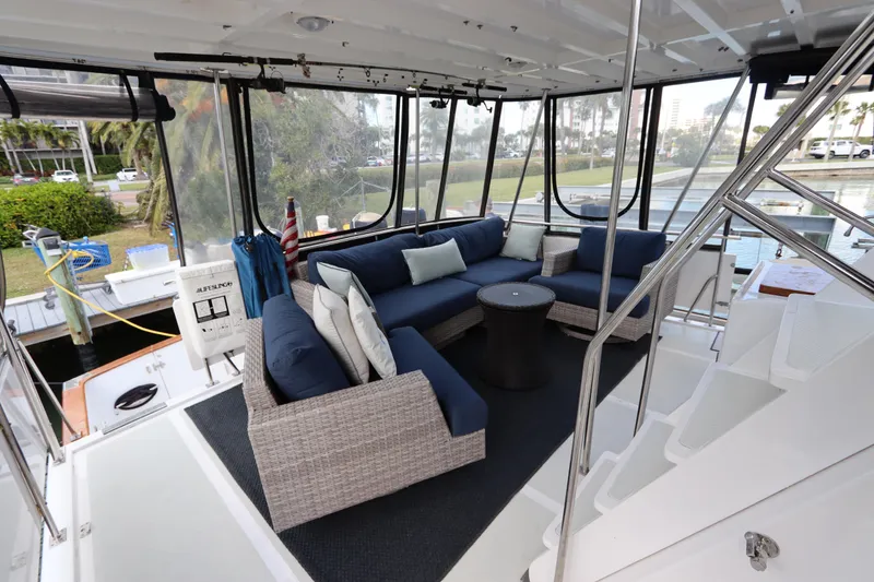 Slide: The Image of 2005 DeFever 49 Cockpit Motor Yacht interior with blue cushioned seating and panoramic windows. - 22