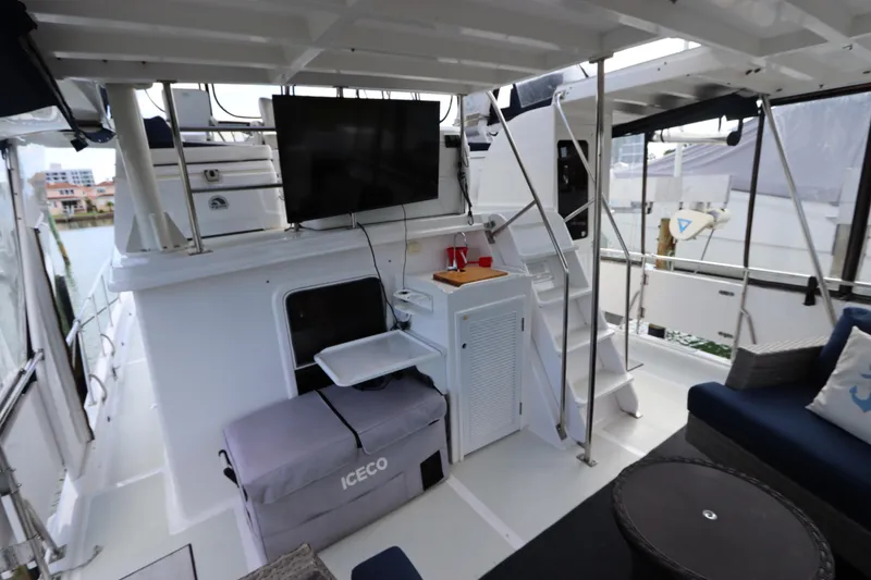 Slide: The Image of 2005 DeFever 49 Cockpit Motor Yacht interior with TV, seating, and storage. - 24