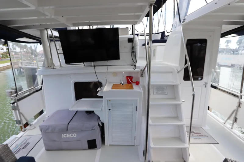 Slide: The Image of 2005 DeFever 49 Cockpit Motor Yacht interior with TV, stairs, and storage. - 25